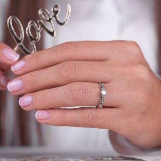 Scattered_green_diamonds_engagement_ring_on_hand