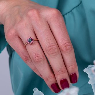 One_of_a_kind_green_sapphire_and_ruby_halo_engagement_ring_on_hand