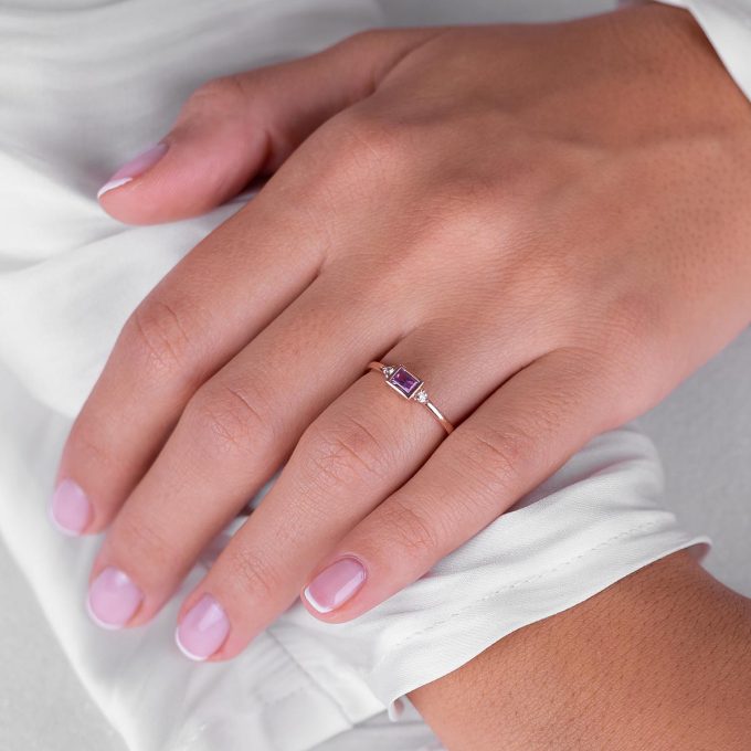 Pink_sapphire_baguette_and_diamond_engagement_ring_on_hand
