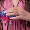 Blue_sapphire_engagement_ring_with_side_diamonds_on_hand
